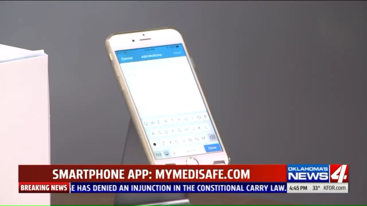 smartphone on a stand showing a medication app screen with a blue header and list area