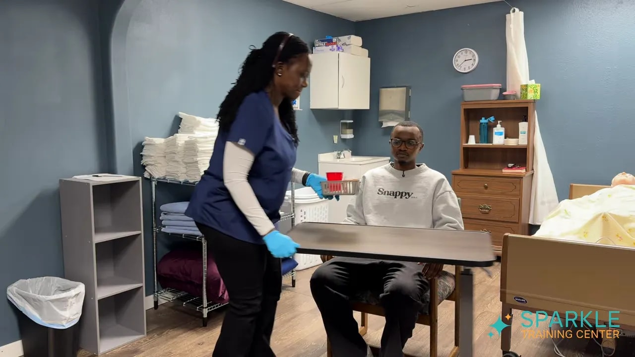 caregiver placing medication supplies and water on an overbed table in front of seated client
