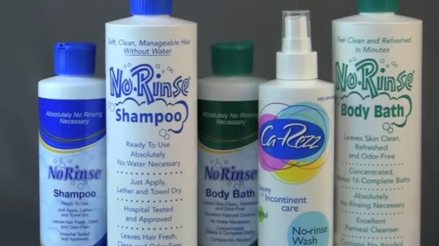 Several no-rinse shampoo and body bath products lined up on a table